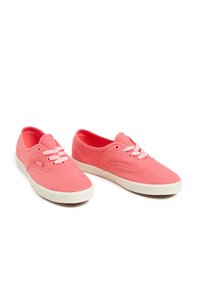 Baskets en toile rose avec des lacets blancs, bout arrondi et design minimaliste. La semelle est blanche et légèrement rembourrée pour le confort.