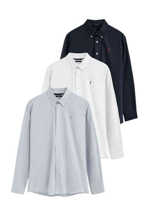 Tres camisas de manga larga con botones en azul claro, blanco y negro con pequeños logos bordados en el pecho izquierdo.