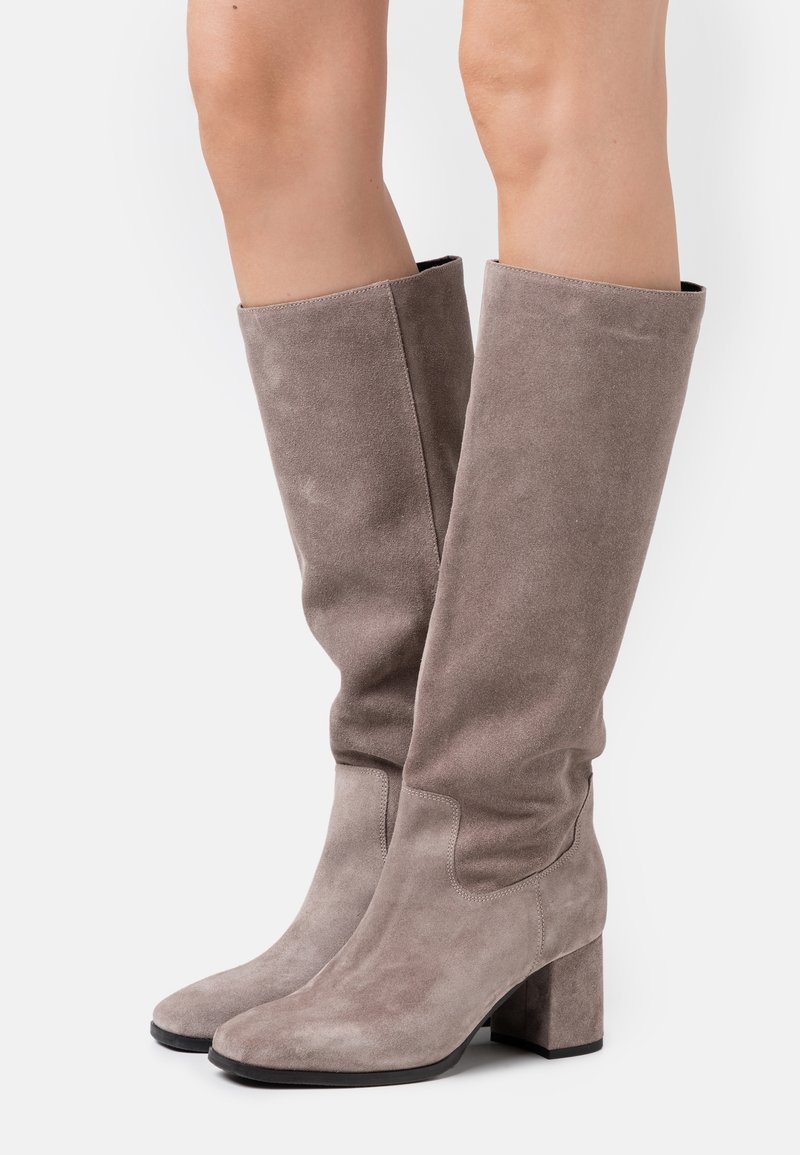 Bottes gris en daim montant au-dessus du genou avec un talon bloc épais, une texture lisse et un design plié en haut. Présentent une silhouette élégante.
