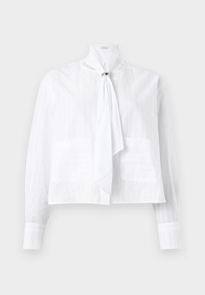 Biela blúzka z ľahkej látky s textúrovaným pruhovaným vzorom, ktorá má dlhé rukávy, vysoký golier a viazaný accent detail.
