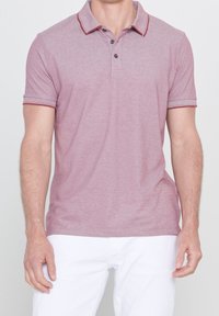 Polo rouge chiné avec un col, une patte de boutonnage à trois boutons et des accents contrastants de rouge foncé sur le col et les manches.