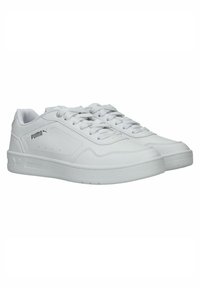 Adidași albi din material sintetic cu o textură netedă, având un design cu șireturi, logo pe lateral și perforații subtile.
