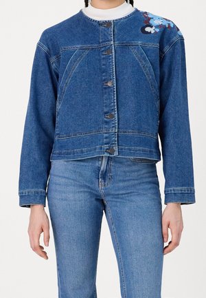 Veste en denim, bleu clair, avec broderies décoratives sur l'épaule, fermeture par boutons et coupe courte. Manches longues et col rond.