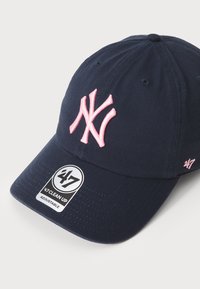 Casquette de baseball marine avec un logo NY rose brodé, réglable, et une étiquette '47 Clean Up sur la visière. Fabriquée en tissu en coton.