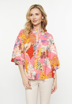 Bloemdruk shirt in roze, met brede mouwen, een knoopsluiting aan de voorkant en gemixte patronen waaronder bladeren en dierenprints.