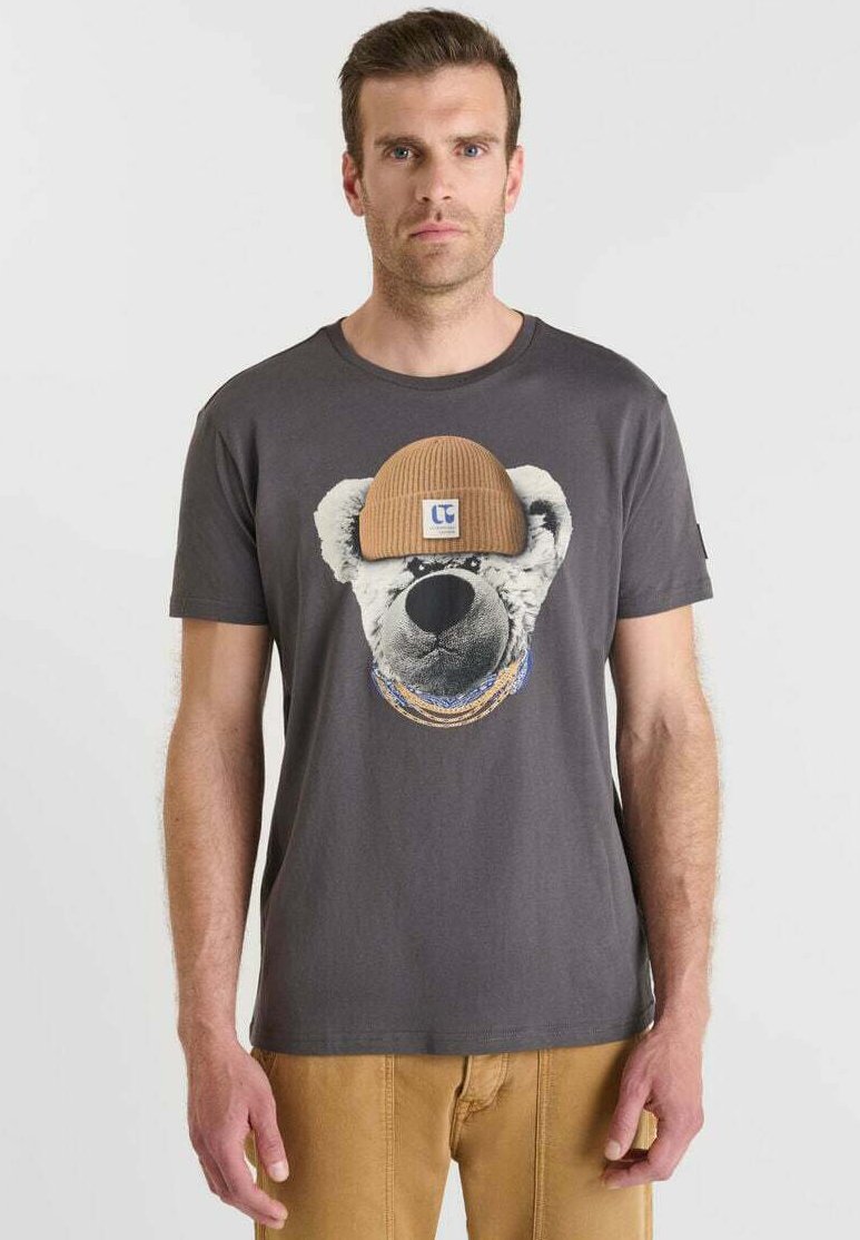 Camiseta gris de algodón con un gráfico de un oso que lleva un gorro de lana beige, con detalles de collar coloridos impresos debajo de la cara del oso.