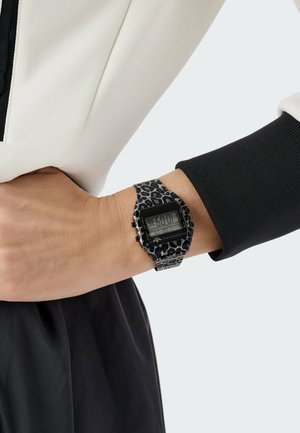 Montre numérique-bracelet avec un bracelet à imprimé léopard noir et gris. Cadran carré affichant l'heure, boîtier noir contrastant et accents métalliques.