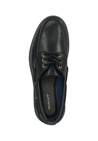 Black leather shoe with round toe, gold eyelets, and laces. Interior features blue lining and brand name “GANT” printed in gold.