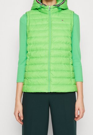 Gilet rembourré vert vif avec une capuche, présentant une texture matelassée, une fermeture éclair frontale et des poches latérales. Accentué par un intérieur multicolore.