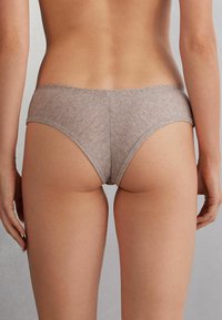 Bruna bomulls-bikiniunderkläder med låg midja, slät yta och subtilt melerat mönster. Ingen synlig hårdvara eller dekorationer.