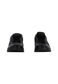 Sneaker in pelle nera con punta arrotondata, lacci piatti e suola in gomma spessa; presenta il marchio dorato sulla linguetta.