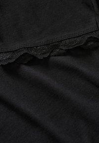 Black fabric with a folded edge featuring a delicate lace trim and neat stitching along the seam.