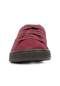 Sneaker in suede bordeaux con suole in gomma marrone, punta tonda e lacci spessi; presenta dettagli in teal sui lati.