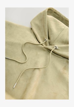 Beige kapuutsiga sweatshirt, mis on valmistatud pehmest, tekstuuriga kangast. Omab reguleeritavat nööri metallist otstega ning on seda iseloomustanud mugav lõige.