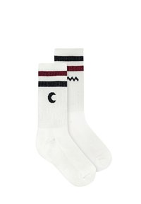 Białe skarpetki do kolan z czerwonymi i czarnymi paskami u góry. Zawierają wzory w kształcie półksiężyca oraz zygzakowate. Wykonane z rypsu.