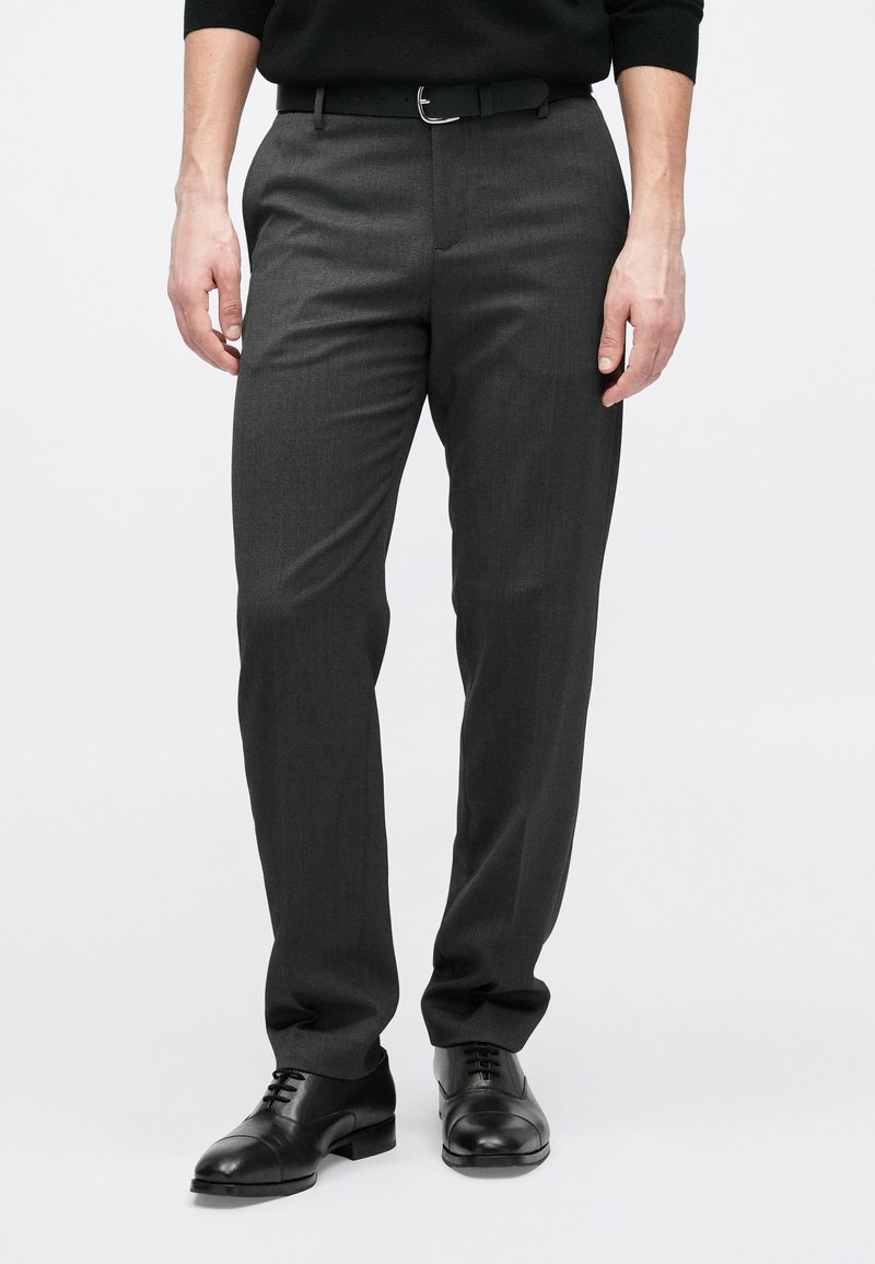 Gray tailored trousers with a subtle texture, featuring a straight leg design and a black belt. Paired with black dress shoes.