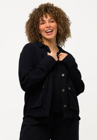 Diepblauwe, gestructureerde button-up overhemdjack met grote zakken, een kraag en een ontspannen pasvorm. Geschikt voor lagen.