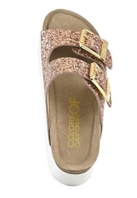 Rosa guld glitter slide sandal med två justerbara guldspännen, vadderad innersula och vit plattformssula. Mjuk textur, avslappnad design.