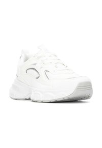 Zapatilla deportiva blanca con parte superior de malla y sintético, suela acolchada, puntera redondeada y sutiles acentos reflectantes en los lados.