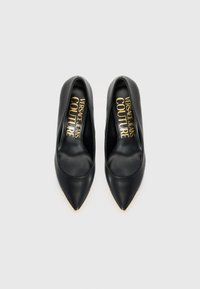 Juodi odiniai aukšti kulniukai su smailiu antgaliu ir auksiniais akcentais ant galiukų. Viduje yra prekės ženklas "VERSACE JEANS COUTURE" auksiniu tekstu.