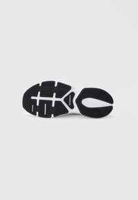 Sort gummisål til sneakers med et tekstureret grebmønster, der har en hvid mellemsål og logo. Designet inkluderer flere riller og konturer.