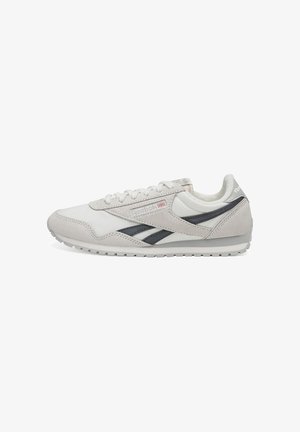 Adidași gri deschis din material suede și piele, cu o dungi gri închis și logo-ul Reebok. Design cu profil redus, cu șireturi. Talpă din cauciuc.