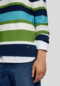 Gestreifter Strickpullover mit blauen, grünen und weißen horizontalen Linien, navyfarbene Akzente und ein kleines Metalllogo auf der unteren linken Seite.