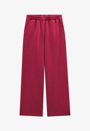 Spodnie o szerokich nogawkach w ciemnoróżowym kolorze z elastycznym pasem i bocznymi kieszeniami, ułożone płasko na białym tle.