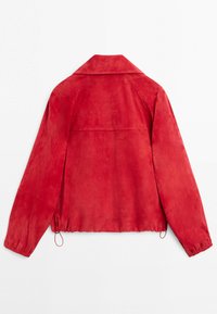 Červený semišový kabát s dlouhými rukávy, širokým límcem a nastavitelnými šňůrkami na spodním okraji, zobrazený zezadu na bílém pozadí.