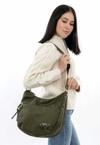 Borsa textured verde oliva con una forma morbida, dotata di una zip argento, tracolla regolabile e dettaglio del logo in rilievo.