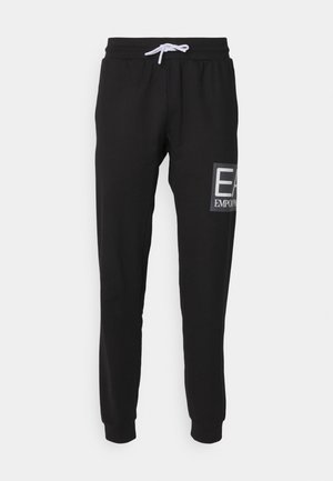 Pantaloni della tuta neri con vita regolabile, gambe affusolate e logo stampato sulla coscia sinistra. Realizzati in un tessuto liscio e leggero.