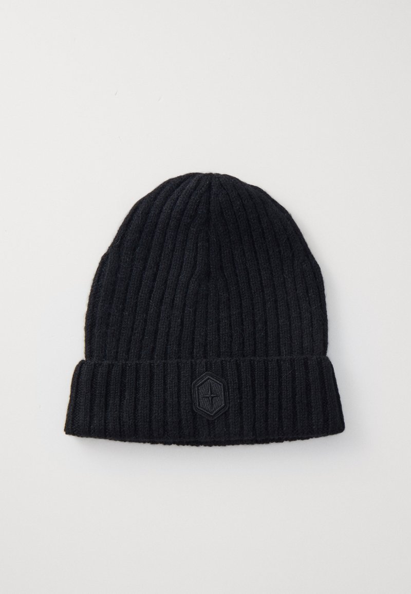 Căciulă neagră din tricot cu model cu bordură pliată și o etichetă texturată în formă de hexagon pe față. Textură moale a materialului.