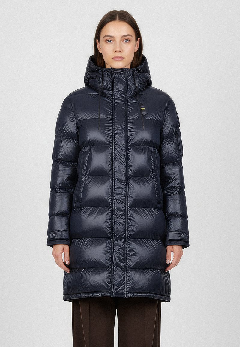 Námořnická pufovaná bunda s lesklým povrchem, do délky kolen, s vysokým límcem, předním zipovým zapínáním a dvěma velkými kapsami. Součástí je nastavitelná kapuce.