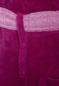 Purple robe with a soft terry texture, featuring a light pink textured band and sash. The fabric appears plush and thick, offering warmth.