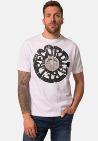 Vit T-shirt med en stor svart grafik med skivbolagsdesign, korta ärmar och en avslappnad passform. Tillverkad av bomull med en mjuk textur.