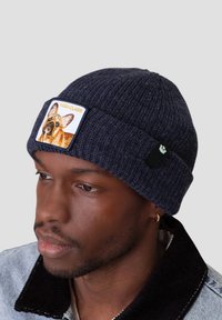 Navy ribbed knit beanie with an embroidered patch featuring a dog and "HIGH CLASS" text. Side logo tag visible.