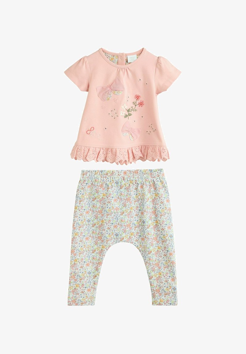 Haut pour bébé rose à manches courtes avec broderies florales et papillons, associé à un legging blanc à imprimé floral et taille élastique.