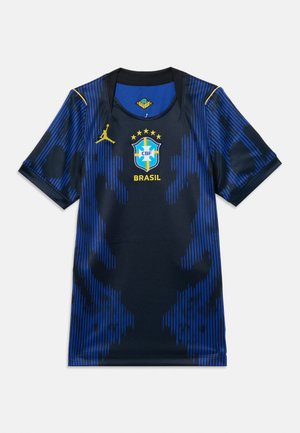 Modrý a čierny brazílsky futbalový dres so žltým logom Jordan a brazílskym erbom s piatimi hviezdami nad ním.