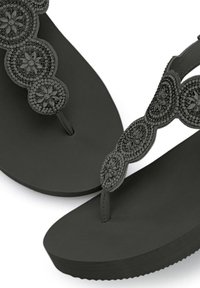 Infradito neri con suola strutturata, cinturino decorativo con perline e motivi floreali, e plantare imbottito per il massimo comfort.