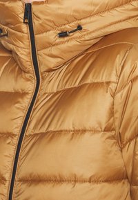 Gewatteerde jas in een warme gouden tint, met een horizontaal gestikt ontwerp, een gladde satijnen textuur en een zwarte ritssluiting met een verstelbare trekkoordkap.