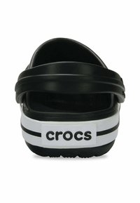 Zwarte Crocs met twee dikke zwarte banden, witte accentband en logo. Gestructureerde voetbed, open ontwerp en ronde achterkant. Duurzaam materiaal.