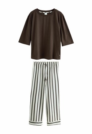 Brown loose-fit elbow sleeve top paired with white wide-leg pants featuring vertical black stripes and an elastic drawstring waistband.