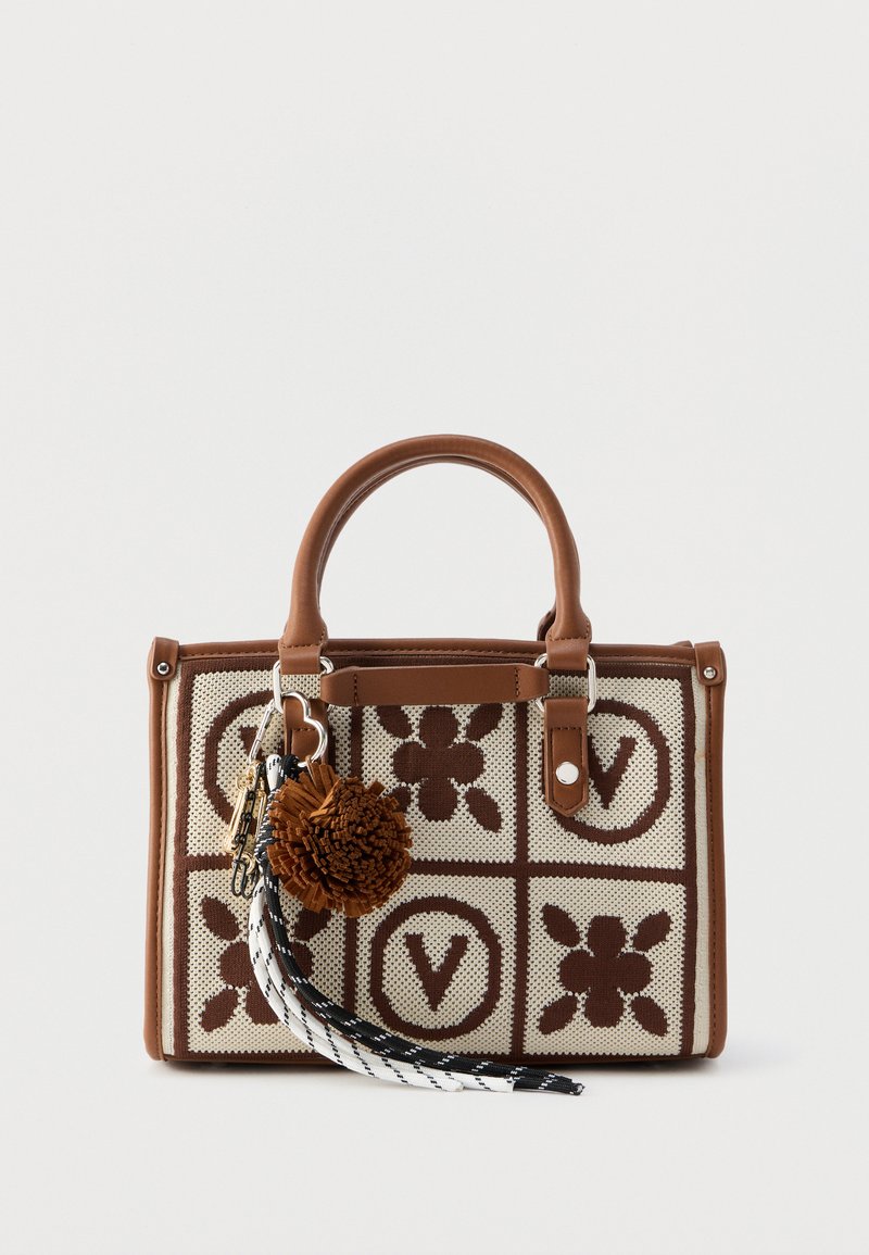 Brown and cream handbag with floral and "V" patterns, featuring a round pom-pom and black-and-white braided tassel keychains on the handle.