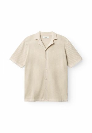 Cárdigan beige de manga corta de punto con cierre de botones, cuello puntiagudo y patrón de canalé vertical texturizado.