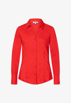 Chemise rouge à manches longues, cintrée, boutonnée, avec un col pointu et des coutures ajustées pour une coupe slim.