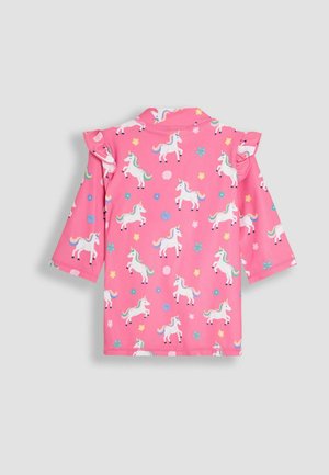 Camicetta rosa a maniche corte con motivo unicorno e accenti multicolori. Dettagli a volantino sulle spalle. Tessuto morbido e elasticizzato.