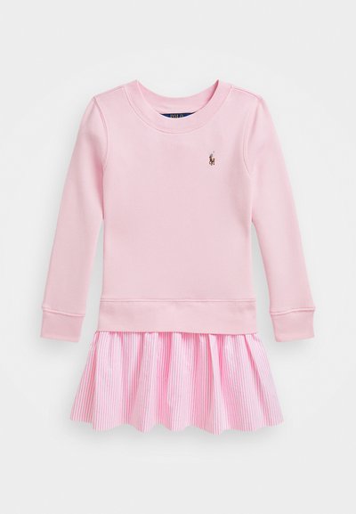 Roosa pikkade varrukatega kleit, millel on ühekordne ülaosa ja flokeeritud seelik, millel on vertikaalsed roosad triibud. Kleit on lõpetatud kõverate servade ja väikese logo kaunistusega.