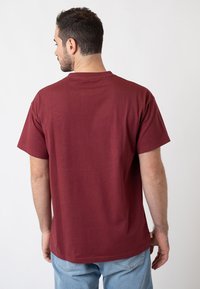Burgundy cotton t-shirt with short sleeves and a crew neck, featuring a relaxed fit and plain back design.