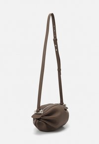 Brown leather handbag with a rounded, gathered shape, adjustable strap, and silver hardware. Features a zip closure along the top.