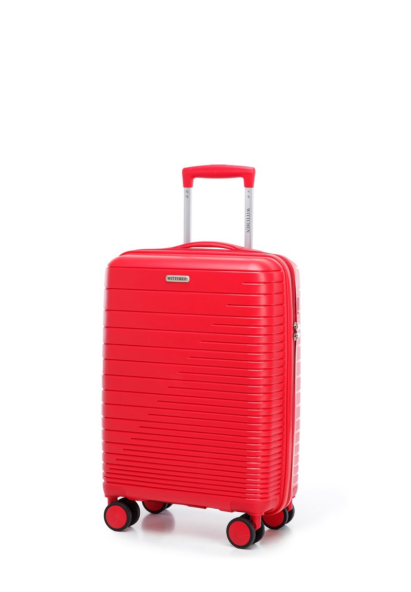 Valise rigide rouge avec des rainures horizontales, poignée rétractable, quatre roues jumelées à rotation multidirectionnelle et fermeture éclair. Texture lisse.